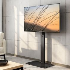 a flat screen tv sitting on top of a metal stand