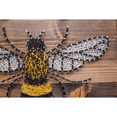 a string art bee sitting on top of a wooden table