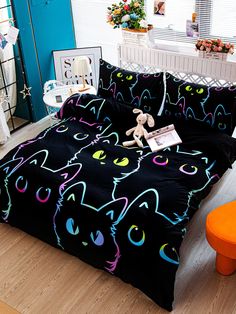 a black bed with colorful cats on it