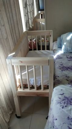 a baby crib sitting next to a bed in a bedroom