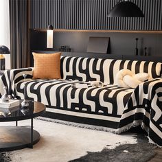 a living room with black and white striped couches, lamps and rugs on the floor