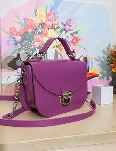 A small handbag made in an incredibly beautiful and attractive violet color. Beautiful, charming and very comfortable. Despite its small size, it easily fits everything you need. Our handbag is made of smooth genuine leather, with a leather lining inside. All edges are processed and painted by hand, making the handbag look neat and expensive. There are two pockets in total inside the bag. The bag closes with a zipper and lock. Size: 8 x 6 x 3 inches (20 x 16 x 8 cm). Pink Leather Box Bag For Gift, Pink Leather Box Bag Perfect For Gifts, Purple Leather Shoulder Bag With Detachable Handle, Purple Top Handle Box Bag For Daily Use, Purple Crossbody Shoulder Bag With Detachable Handle, Chic Purple Shoulder Bag With Mobile Phone Pocket, Purple Leather Shoulder Bag With Adjustable Strap, Purple Detachable Handle Crossbody Shoulder Bag, Chic Purple Shoulder Bag For Mobile Phone