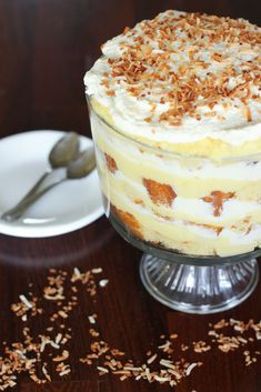 a cake with white frosting and sprinkles sits on a table next to a glass of milk