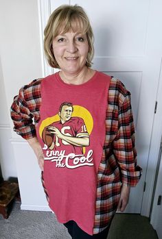 a woman standing in front of a white door wearing a red shirt and black pants