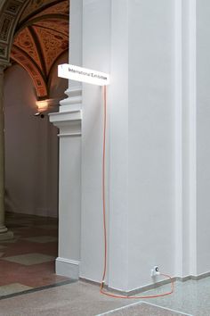 an orange cord is connected to a white sign