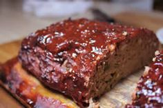 sliced meatloaf on a cutting board with sauce