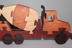 a wooden toy truck with puzzle pieces on it