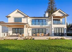 a large white house sitting on top of a lush green field