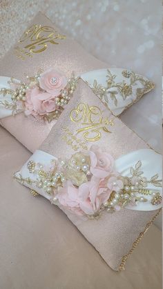 two decorative pillows with flowers and pearls on them