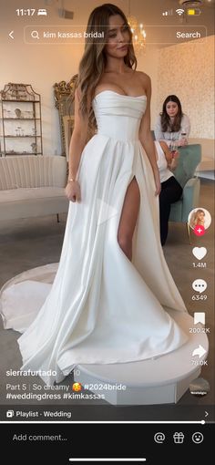 a woman in a white dress is taking a selfie with her cell phone screen