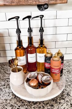 several different types of soaps and lotions on a white plate in front of a tiled wall