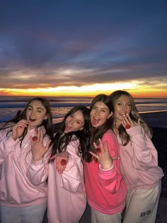 four girls posing for the camera with their fingers in the air