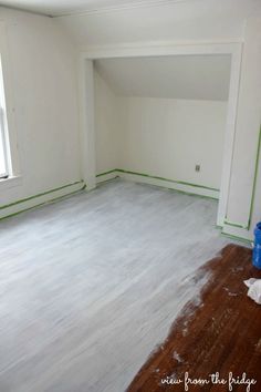 an empty room with hard wood floors and white paint on the walls is being painted