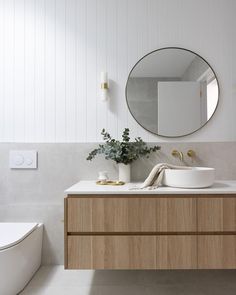 a bathroom with a sink, mirror and toilet paper roll on the counter next to it