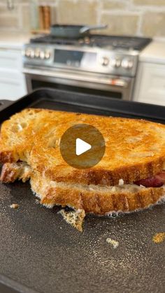 a toasted sandwich sitting on top of a black pan in front of an oven