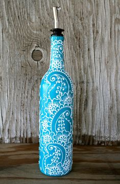 a blue and white bottle sitting on top of a wooden table next to a wall