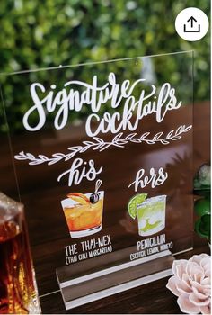 there is a sign that says signature cocktails on the table next to some drinks