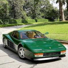 a green sports car is parked on the street