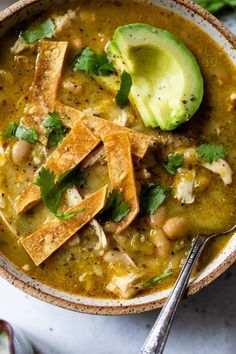 a bowl of soup with tofu, beans and avocado