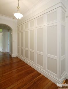 an empty room with white walls and wood floors