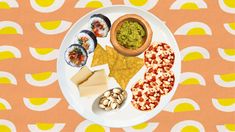 a white plate topped with different types of food next to a bowl of guacamole