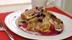 a white plate topped with french toast and berries