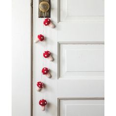 red and white mushrooms are hanging on the front door