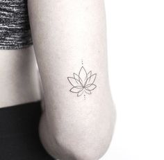 a woman's arm with a small flower tattoo on the left side of her arm