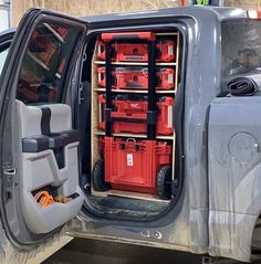 the inside of a truck with its doors open and many red boxes in the back