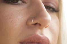 a close up of a woman's nose and nose ring