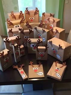 some brown paper bags with reindeer faces and noses on them are sitting on a table