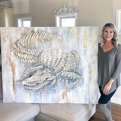 a woman standing next to a large painting