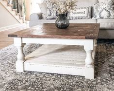 a white coffee table sitting on top of a rug in a living room next to a couch