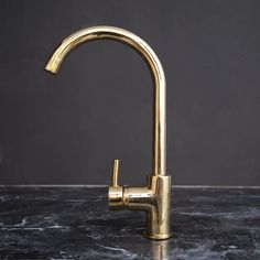 a gold faucet on a black counter top