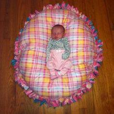 a baby is laying in a pink and yellow blanket