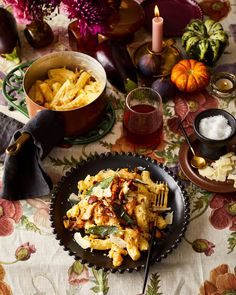 a black plate topped with pasta next to other dishes