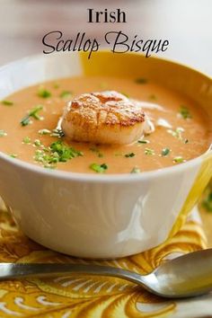 a white bowl filled with soup topped with scallops