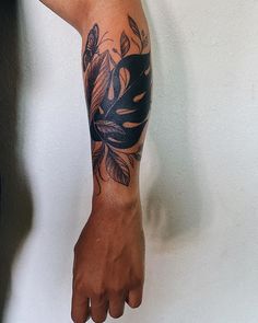 a person's arm with a black and grey tattoo design on the left arm