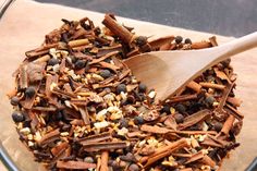 a wooden spoon in a bowl filled with spices