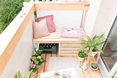 a small balcony with potted plants and pillows