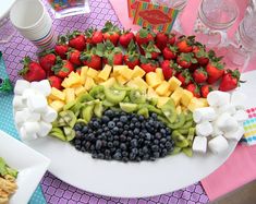 a platter filled with fruit and marshmallows on top of a table