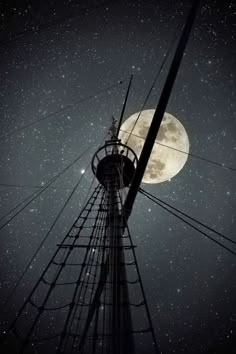 the full moon shines brightly in the night sky above an old telephone pole and power lines