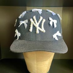 Custom Ny Yankee Hat Adorned With Pearls And Bows Coquette Vibes Colors Available: Black, Navy, Pink, Red, Brown, Grey & Tan #Coquette #Customhat #Yankeesha Custom Ny Hat, Ny Hat Outfit, Pearl Fitted Hat, Fitted Black Themed Hat, Yankee Fitted Hats, Girly Hat, Customized Hats, Yankees Hat Fitted