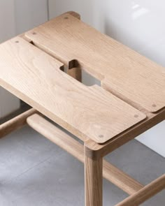 a wooden stool with a hole in the seat and no one around it on the floor