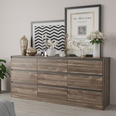 a dresser with flowers and pictures on it