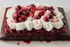 a piece of chocolate cake topped with whipped cream and cherries