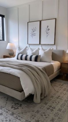 a large bed sitting in a bedroom next to two framed pictures on the wall above it