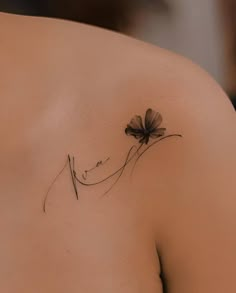 a woman's shoulder with a flower tattoo on it