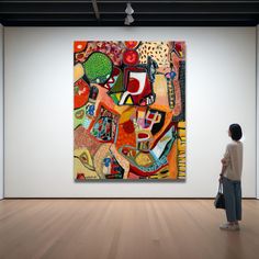 a woman standing in front of a large painting