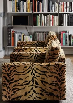 a living room filled with lots of furniture and bookshelves covered in animal print